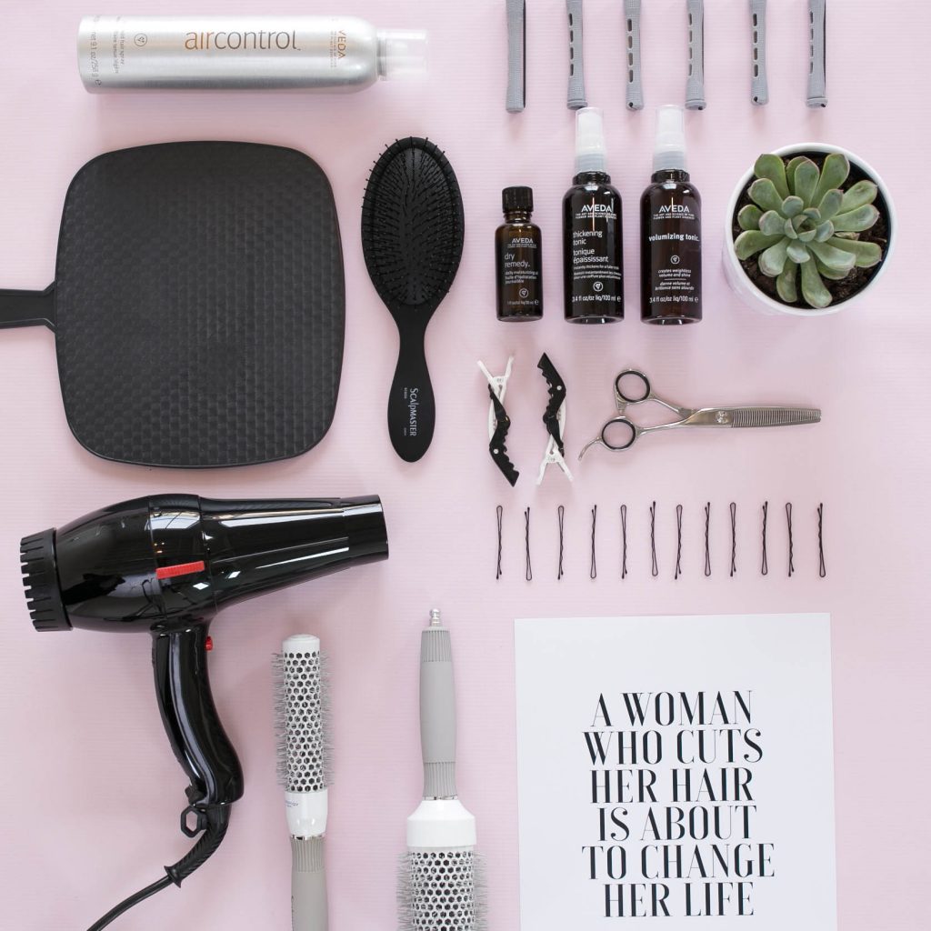 hair tools including a blow dryer, mirror, a brush, and more