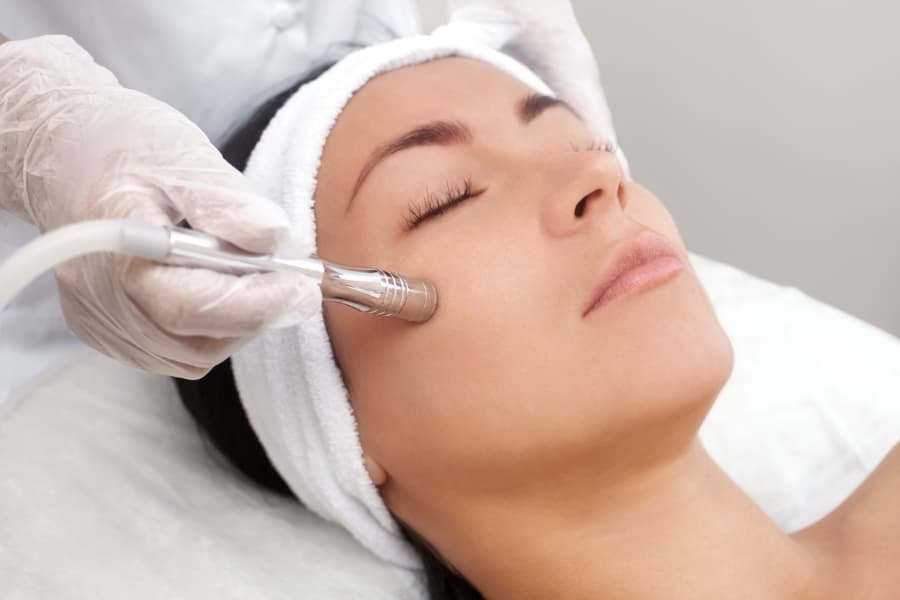 Person laying on table receiving a facial dermabrasion