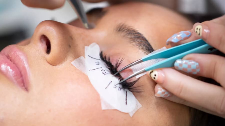 licensed cosmetologist performing lash services for client