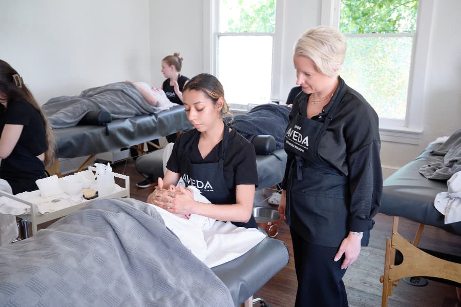 massage therapy student at aveda learning from instructor