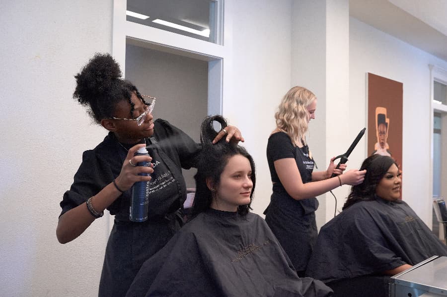 students in cosmetology attire receiving hair services at Aveda Inspire Greatness Institutes
