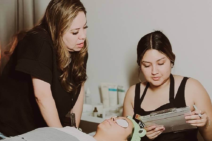 makeup artist applies cosmetics to a clients face at inspire greatness aveda institutes