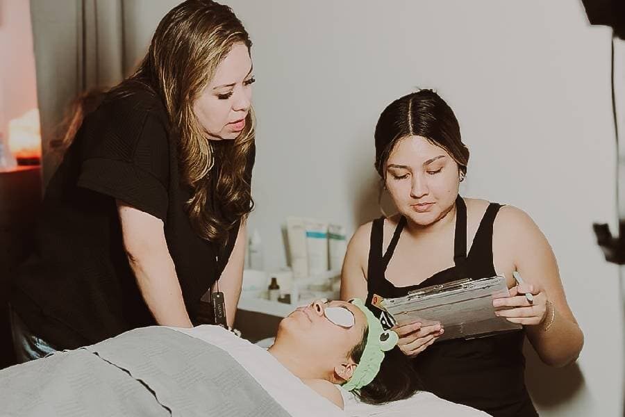makeup artist applies cosmetics to a clients face at inspire greatness aveda institutes