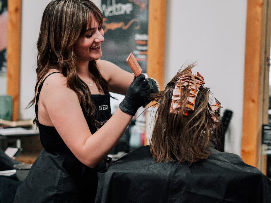 beauty school student working on a client with her cosmetology license