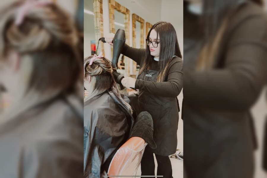 stylist blowing out clients long hair