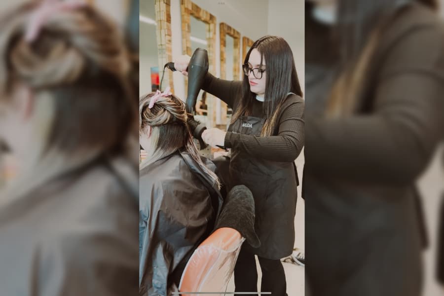 stylist blowing out clients long hair